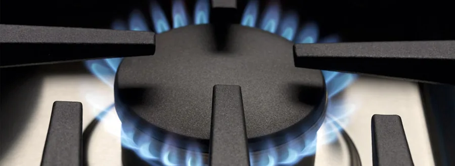 Blue flame on a gas burner under a cast-iron grate
