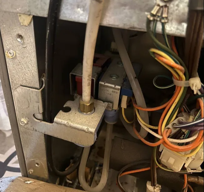 Water inlet valve and wiring behind an appliance panel